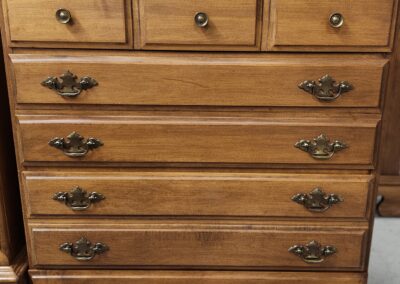 Wooden chest of drawers with antique-style handles.