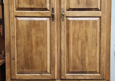 A wooden cabinet with two doors and two drawers at the bottom.
