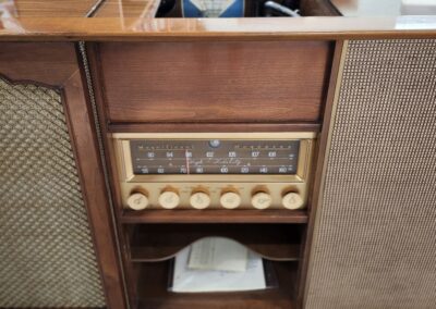 Vintage wooden radio console with knobs and speaker grills.