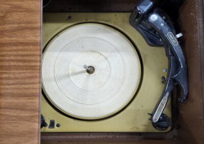 Vintage wooden seismograph with rotating drum and stylus arm.