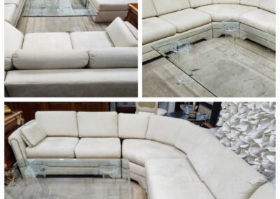 Modern white sectional sofa with a sleek metal frame in a spacious showroom.