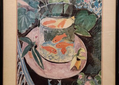 A colorful painting of a glass with a drink on a pink table surrounded by leaves and flowers.