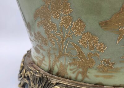 Close-up of ornate ceramic vase with gold floral patterns and decorative base.
