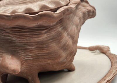 Close-up of a textured ceramic bowl with irregular edges on a matching plate.