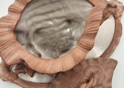 Close-up of a handmade ceramic teapot and cup with organic, textured design.