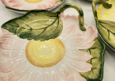 Decorative ceramic plates shaped like flowers with green leaves.