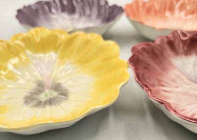 Colorful flower-shaped ceramic plates arranged on a table.