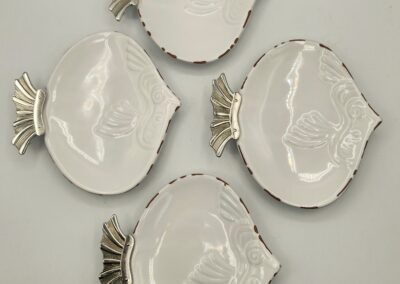 Four decorative white ceramic plates with gold palm leaf accents.