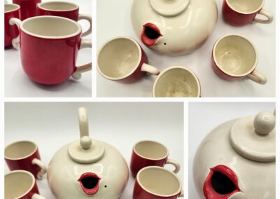 Red and white ceramic tea set with teapot and four cups.
