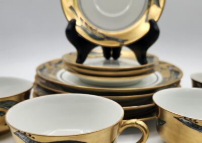 Elegant gold-trimmed tea set with cups and plates.