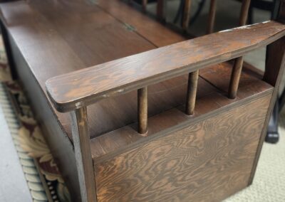 Antique wooden bench with a rustic finish and spindle backrest.