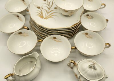 Elegant vintage porcelain tea set with floral design and gold accents.