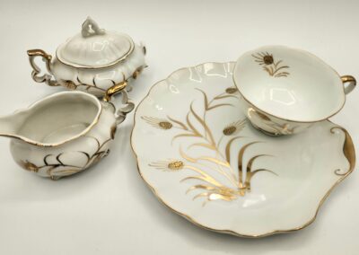 Elegant white porcelain tea set with gold accents and floral designs.