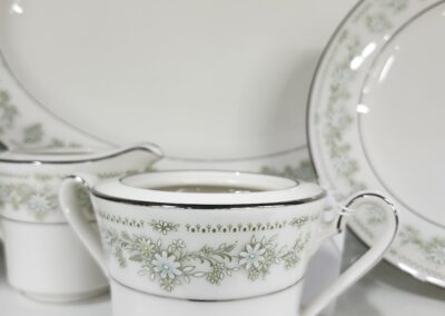 Elegant white porcelain tea set with intricate floral patterns.