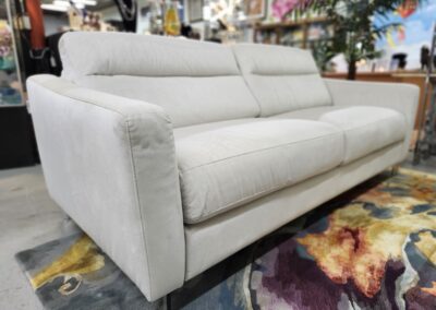 Modern light gray sofa with plush cushions in a cozy living space.