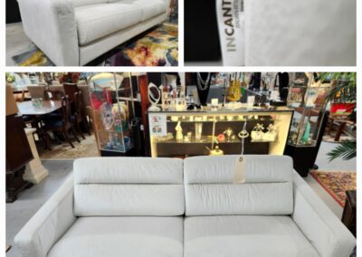 Modern white fabric sofa with adjustable headrests in a showroom.