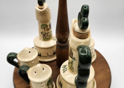 Vintage ceramic condiment set with wooden base and pepper mill.
