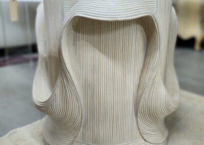 A sculptural wooden chair with a smooth, flowing design.