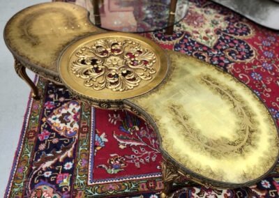 Ornate golden tray with intricate designs on a richly patterned carpet.