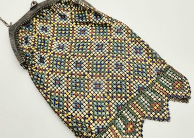 Vintage beaded purse with geometric patterns and metal frame.