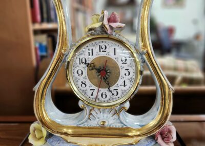 Ornate vintage clock with gold and white detailing.