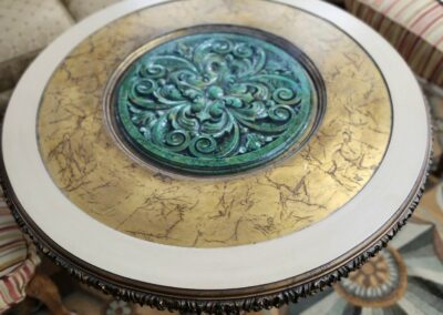 Intricately designed round table with floral and animal motifs.