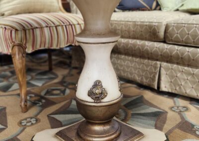 Elegant wooden table leg with intricate design and brass embellishments.