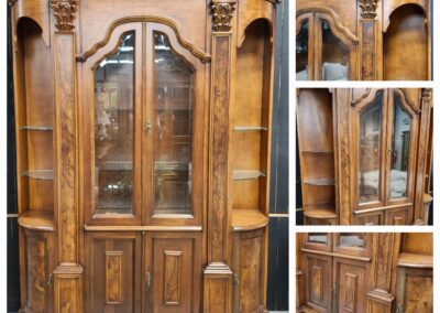 Antique wooden cabinet with glass doors and intricate carvings.
