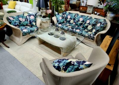 A living room with floral patterned sofas and a beige armchair.