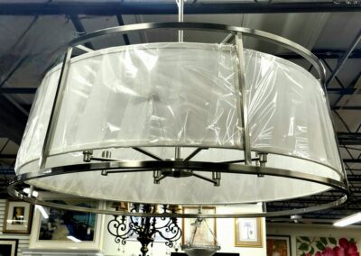 Large circular industrial-style hanging light fixture with a metal frame.