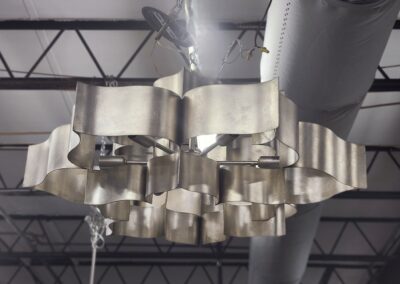 Modern metallic ceiling light fixture with curved panels.