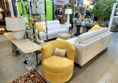 A cozy yellow swivel chair next to a white sofa in a stylish living room setup.
