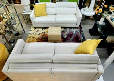 Modern white sofas with yellow cushions in a stylish living room.