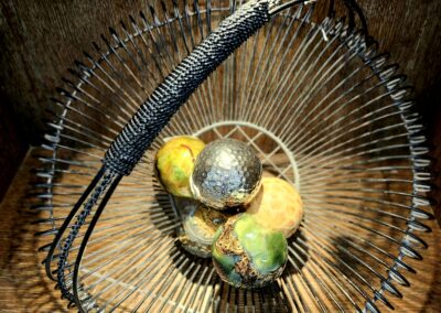 A small bird perched inside a curved wire basket.
