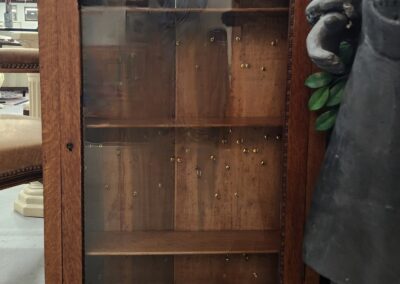 Wooden display cabinet with glass doors and shelves inside.