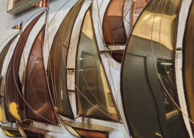 Decorative metal sailboats mounted on a wall.