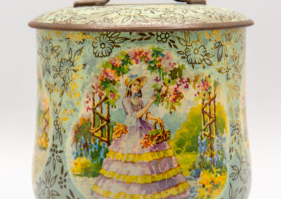 Decorative vintage tin with floral and garden scene design.