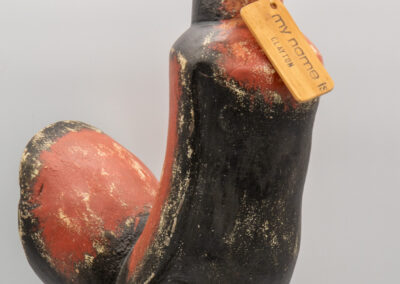Vintage wooden rooster figurine with a tag around its neck.