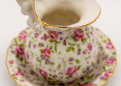 Delicate floral porcelain teacup with matching saucer and gold accents.