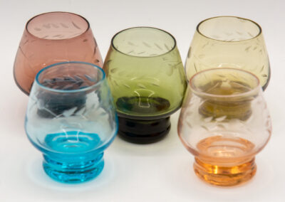 Five colorful translucent glass cups arranged in a group.
