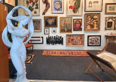 Art gallery room with eclectic framed artworks and a modern white sculpture.