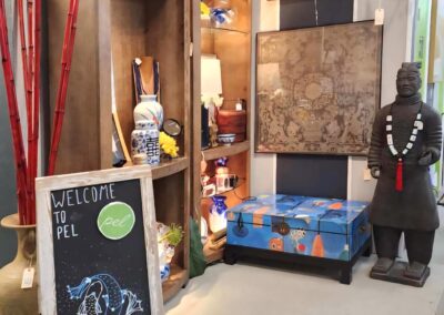Cozy corner with eclectic art, a chalkboard menu, and a statue wearing beads.