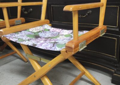 Wooden folding chair with floral fabric seat and backrest.