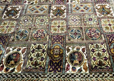 Intricately patterned textile with ornate, colorful designs and figures.
