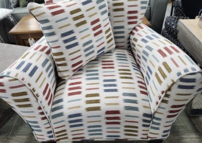 Armchair with colorful striped pattern and matching pillow.
