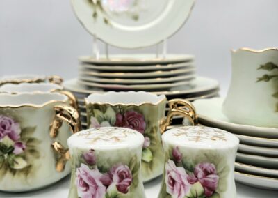 Vintage porcelain tea set with floral designs and gold accents.