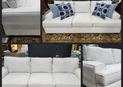Elegant white fabric sofa with patterned cushions and wooden legs.