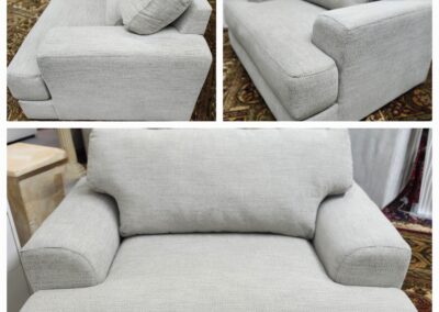A modern gray loveseat with plush cushions and armrests.