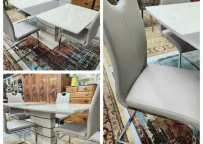 Modern white dining table with sleek chairs on a patterned rug.