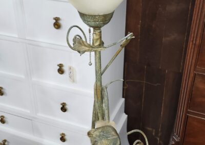Vintage brass floor lamp with a frosted glass shade and decorative elements.
